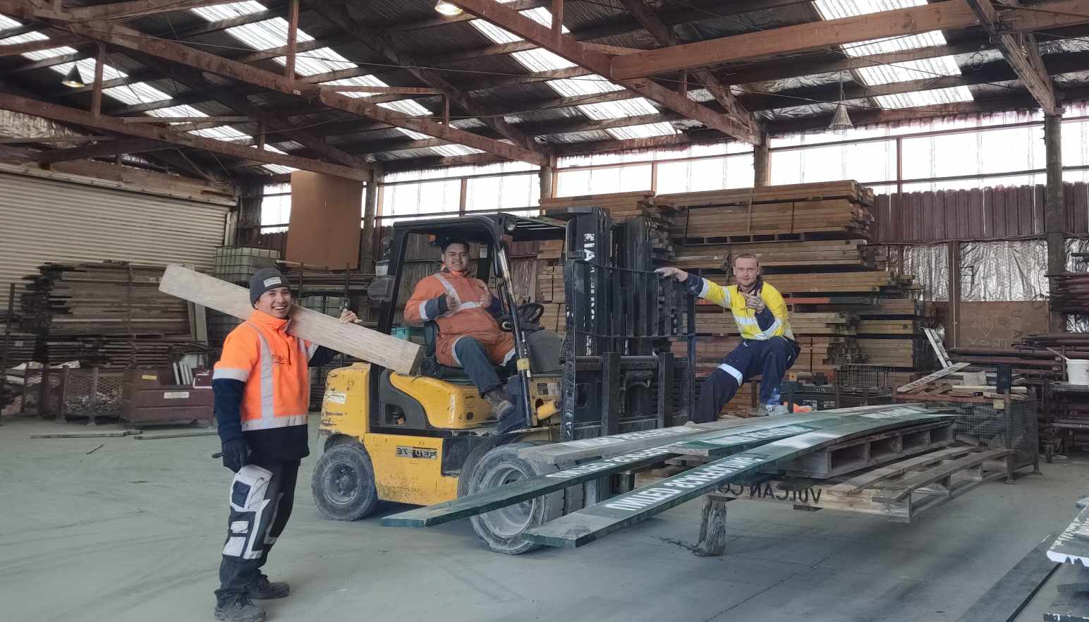 Workers operating machinery in a fabrication workshop
