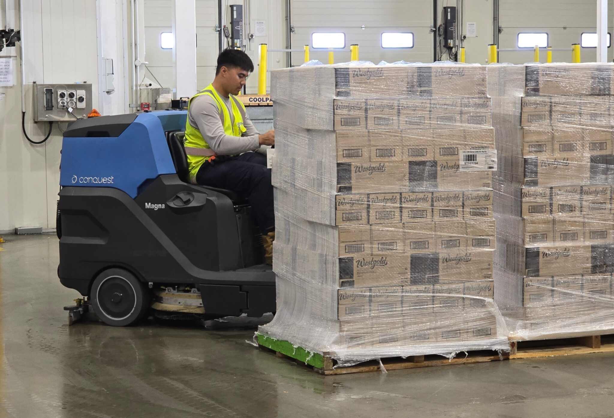 Forklift operator moving a pallet in a warehouse